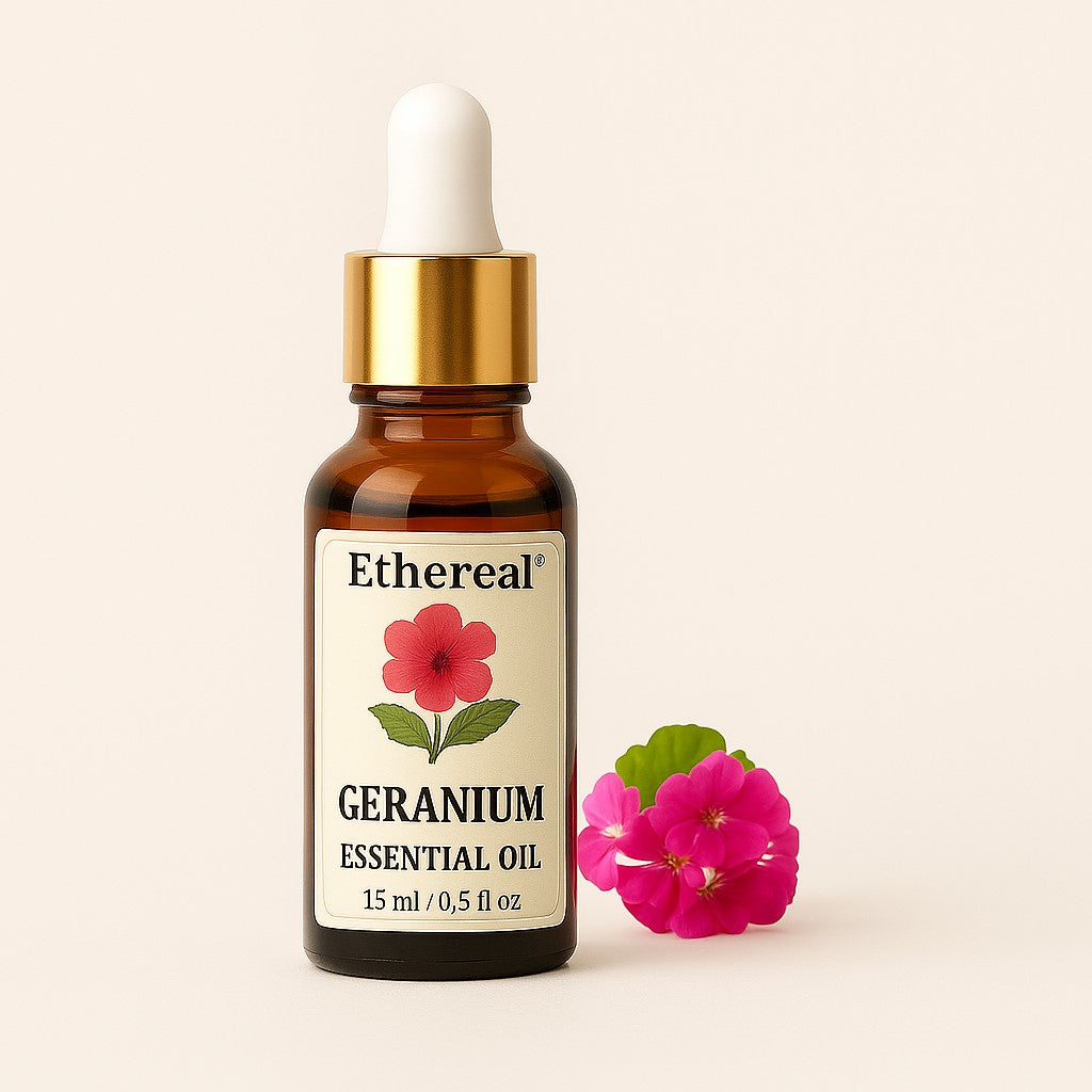 Amber bottle of Geranium essential oil centered on a soft cream background with pink geranium leaves on the right — Ethereal label clearly visible