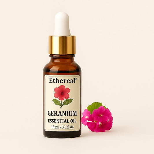Amber bottle of Geranium essential oil centered on a soft cream background with pink geranium leaves on the right — Ethereal label clearly visible